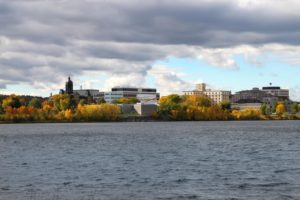 View Fredericton, New Brunswick, along the Saint John River, Canada showing downtown buildings and Fall foliage