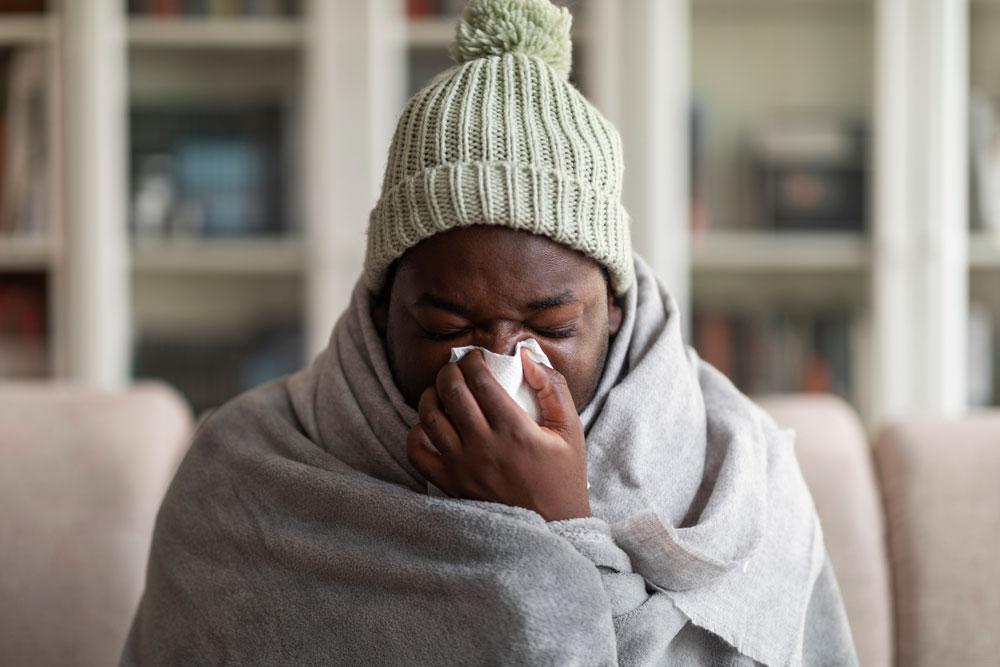 Sick african american guy blowing nose, suffering from cold