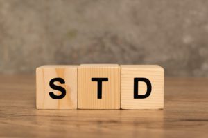 Wooden blocks with std letters on wooden table on grey background