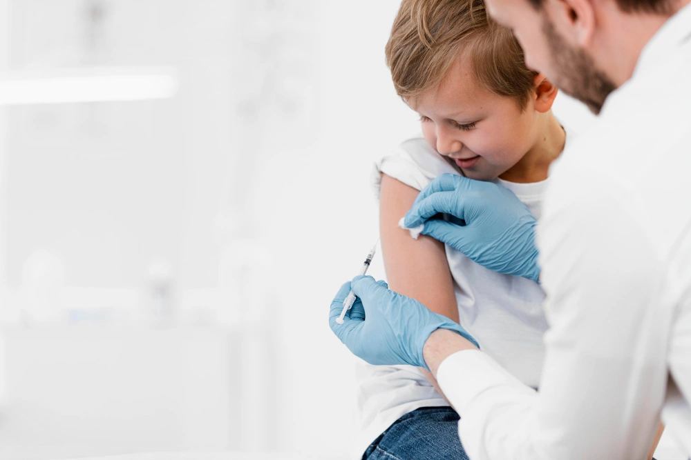 Child receiving vaccination from healthcare worker.
